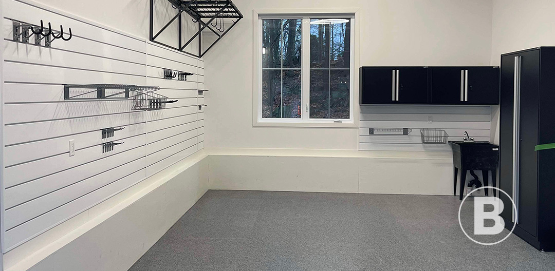 alt="Garage avec plancher gris et rangement mural organisé."