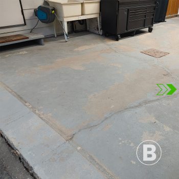 alt="Plancher de garage en béton usé et taché."