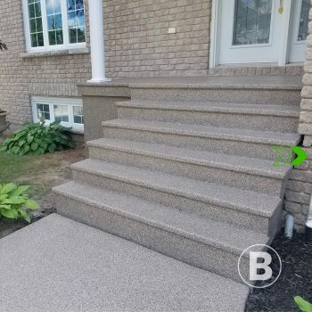 alt="Perron en béton recouvert d’un revêtement gris."