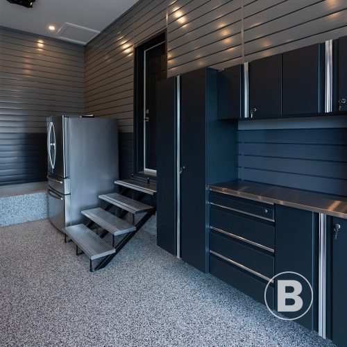 alt="magnifique garage resurfacer en polyaspartique avec flocons de vinyle et aménagement"